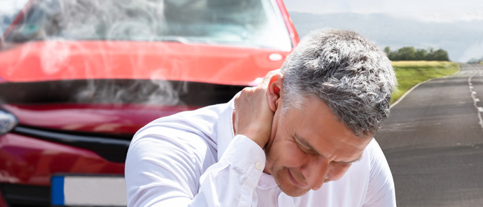 a photo of a guy with neck pain from an auto accident
